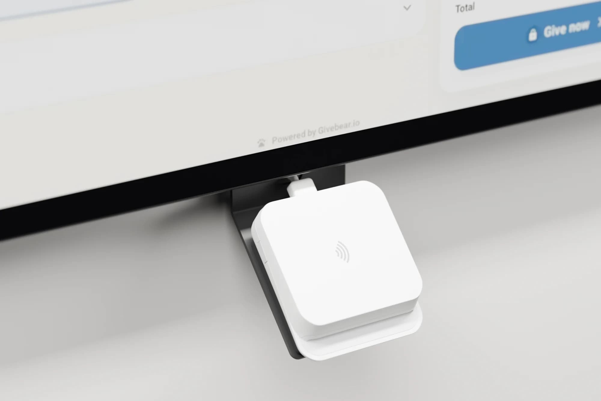 Close-up of the white tap-to-pay card reader mounted under the Givebear kiosk screen